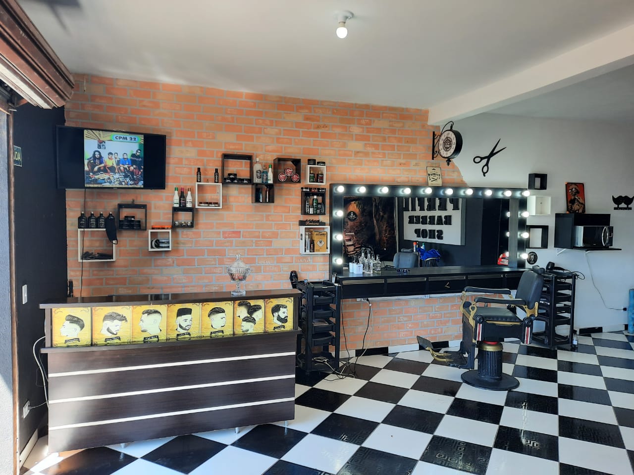 Salão da barbearia com parede de tijolo e cadeira de atendimento